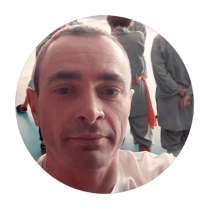 Poznajmy się – portret podczas treningu w tradycyjnym otoczeniu, symbolizujący pasję do rozwoju osobistego i sztuk walki.