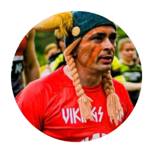 Poznajmy się – wizerunek w hełmie wikinga i z malowaniem na twarzy, wyrażający pasję do sportu, wyzwań i aktywnego stylu życia.