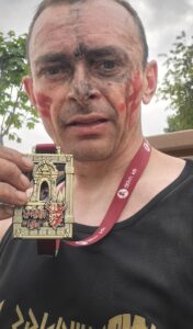 Zmęczenie i satysfakcja wypisane na twarzy – medal w dłoni to dowód na przekraczanie własnych granic i walkę z każdym kolejnym wyzwaniem.