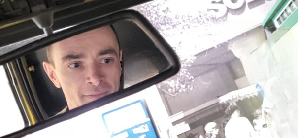 Odbicie w lusterku wstecznym – spojrzenie pełne refleksji i koncentracji, symbolizujące moje Dossier doświadczeń oraz różnorodne perspektywy w pracy twórczej