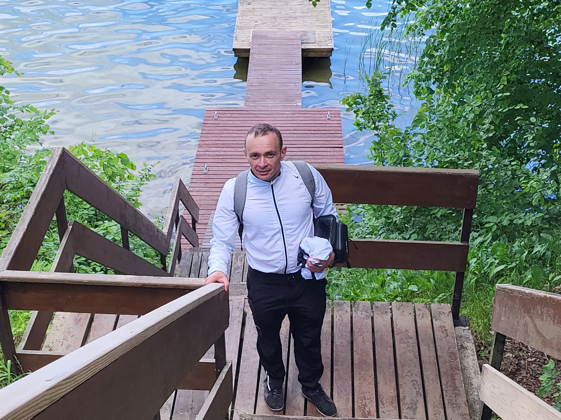 Spacer po drewnianym pomoście na Mazurskiej Pętli Rowerowej. Szlak prowadzi przez malownicze jeziora i urokliwe zakątki natury.