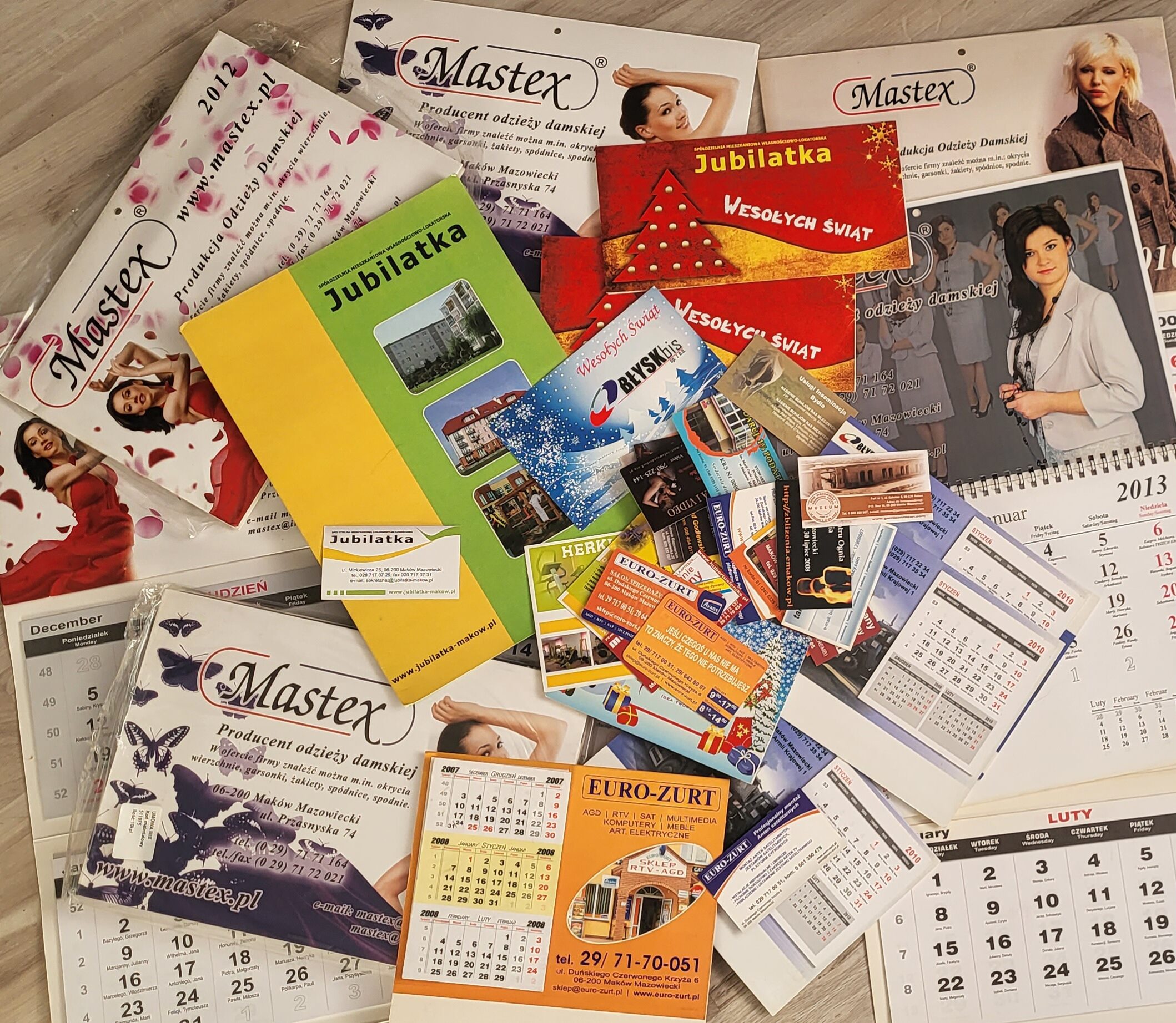 Zestaw różnorodnych projektów graficznych, w tym kalendarze, foldery i wizytówki, ukazujących wszechstronność i profesjonalizm w budowaniu portfolio kreatywnego.