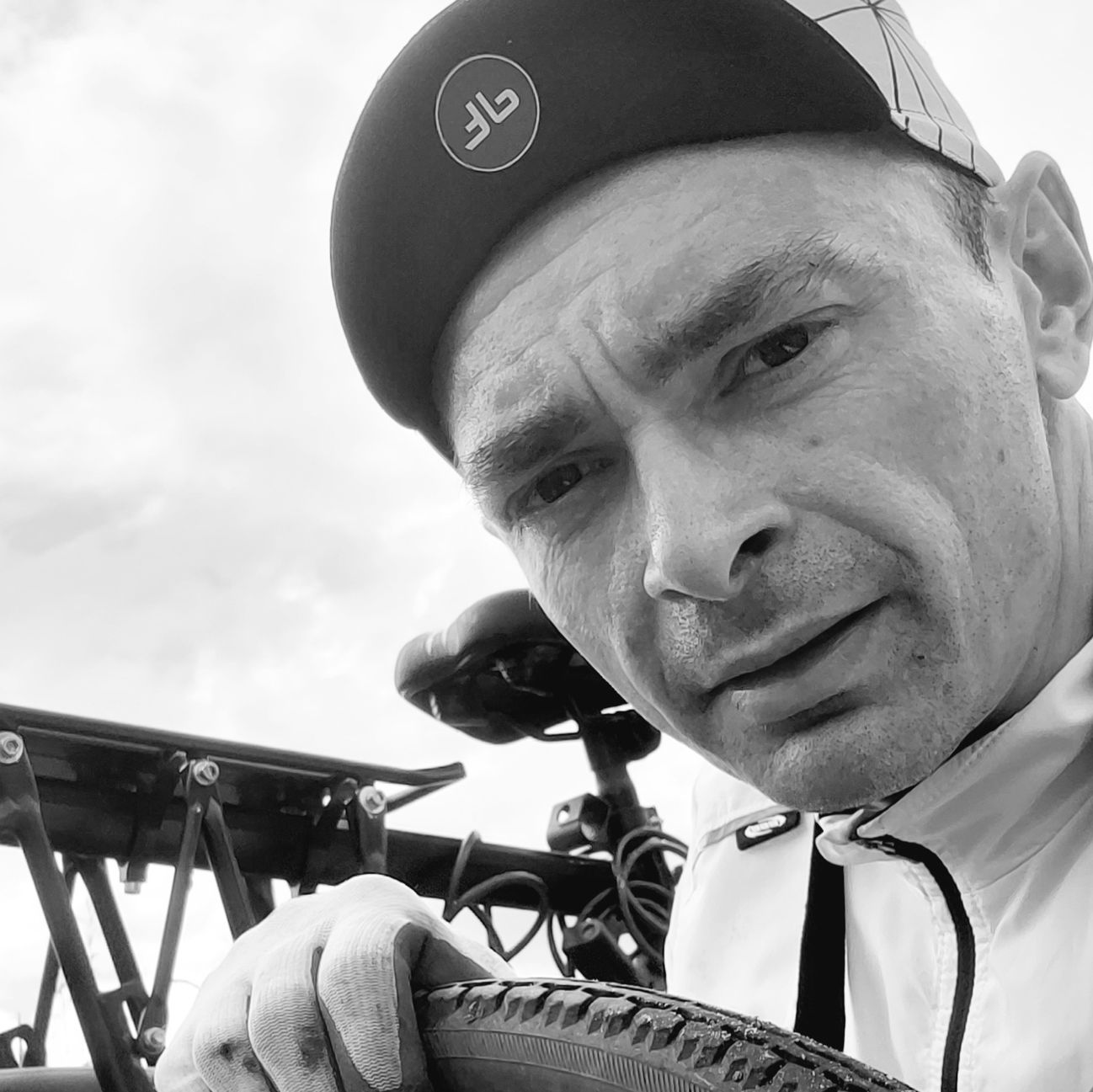 Autor e-booka 30+1 Praktycznych wskazówek dla rowerzysty w czarno-białej fotografii z rowerem w tle.